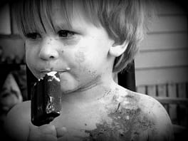 dirty face kid eating